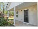Inviting front porch and entrance features a black front door with white pillars at 15 Sloane Ct, Covington, GA 30016