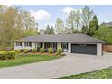 Classic one-story home with a modern color scheme, black trim, a well-kept lawn, and a wide driveway at 2376 Academy Ne Ct, Atlanta, GA 30345
