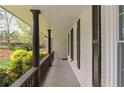 Inviting covered porch with brick siding, black columns, and a railing, offering a relaxing outdoor space at 2376 Academy Ne Ct, Atlanta, GA 30345