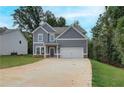 Two-story home featuring gray siding, white trim, an attached two-car garage, and a concrete driveway at 1097 Bodega Loop, Locust Grove, GA 30248