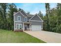 Two-story home featuring gray siding, white trim, an attached two-car garage, and a concrete driveway at 1097 Bodega Loop, Locust Grove, GA 30248