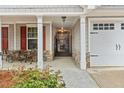 Inviting walkway leading to the front door, with a quaint seating area and two car garage at 126 Cottage Club Dr, Locust Grove, GA 30248