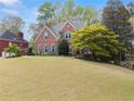 Beautiful brick home with a lush front lawn, showcasing its classic architecture and mature landscaping at 1870 Chattahoochee Run Dr, Suwanee, GA 30024
