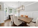 Elegant dining room featuring wainscoting, hardwood floors, and a modern light fixture at 95 Nesbit Reserve Ct, Alpharetta, GA 30022