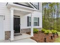 Close-up of a home's entry featuring a black front door, white pillars, and neatly landscaped yard at 3736 Chevington Se Ct, Atlanta, GA 30354
