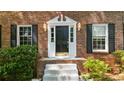 Inviting entryway featuring a black front door with sidelights, white trim, and a brick facade at 5145 Davantry Dr, Dunwoody, GA 30338