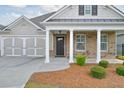 Inviting front entrance with brick accents, columns, and well-maintained landscaping at 807 Bridget Sw Walk, Powder Springs, GA 30127