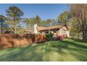 Picturesque home featuring wood fence, lush garden beds, and a well-maintained lawn at 460 Haynes Creek Circle, Oxford, GA 30054