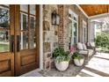 Inviting front porch featuring stone accents, an outdoor seating area, and a warm, welcoming entrance at 156 Lake Forrest Ne Ln, Atlanta, GA 30342