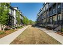 A serene community street with well-maintained lawns, sidewalks, and inviting townhouse facades on either side at 938 Catamaran Ct, Alpharetta, GA 30005