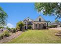 Beautiful brick home with manicured lawn and mature trees, with blue skies in the background at 1950 Lancaster Se Dr, Conyers, GA 30013