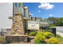 Attractive entrance sign to Towne Lake Hills Townhomes with stone base and mature landscaping at 309 Vista Ln, Woodstock, GA 30189