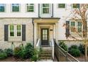 Inviting front entry with brick accents, a covered porch, and a well landscaped garden at 309 Vista Ln, Woodstock, GA 30189