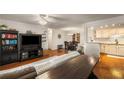 Open concept living room with hardwood floors, media center, and view into dining and kitchen at 408 Brighton Pt, Atlanta, GA 30328