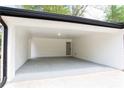 Spacious attached carport with white brick walls and a door to the backyard at 4506 Dorset Dr, Decatur, GA 30035