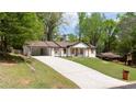 Landscaped front yard featuring a long driveway and a renovated single-story home at 4506 Dorset Dr, Decatur, GA 30035