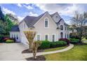 Angle view of a bright two-story home and driveway, with a manicured lawn and lush landscaping at 1900 Denton Walk Ct, Marietta, GA 30062