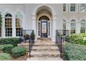Elegant home entrance featuring a stone pathway, iron railings, and manicured greenery at 1900 Denton Walk Ct, Marietta, GA 30062