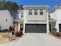 Attractive townhome featuring a two-car garage and well-manicured landscaping at 5576 Rockfern Drive, Lilburn, GA 30047