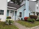 Charming light blue townhouse with a chimney and pretty bushes in the front yard at 5961 Sherwood Trce, Stonecrest, GA 30038