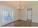 Bright dining room featuring wood floors, contemporary light fixture, and double glass doors at 8304 Ephesus Church Rd, Villa Rica, GA 30180