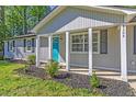 Inviting home exterior featuring a blue front door, fresh landscaping, and light gray siding at 8304 Ephesus Church Rd, Villa Rica, GA 30180