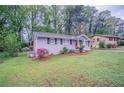Cozy home featuring a landscaped front yard with mature trees and blossoming shrubs at 2038 Thomasville Se Dr, Atlanta, GA 30315
