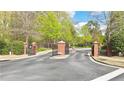 Gated community entrance with brick pillars, providing security and enhancing curb appeal at 3546 Flycatcher Way, Duluth, GA 30097