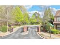 Community entrance with brick pillars, a gated entry, and lush landscaping creating a welcoming atmosphere at 3546 Flycatcher Way, Duluth, GA 30097