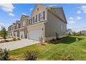 Exterior view of townhomes with green lawns, manicured bushes, and ample parking space at 847 Pensive Run, Dacula, GA 30019