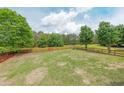Expansive backyard with a red fence surrounding the perimeter for privacy and security at 31 Vine Creek Ln, Acworth, GA 30101