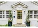 Close-up of the inviting yellow front door with sidelights, potted plants, and decorative accents at 703 Cumberland Ne Cir, Atlanta, GA 30306