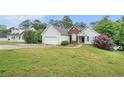 Attractive one-story home with an attached garage and a lush green lawn at 206 Towler Dr, Loganville, GA 30052