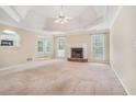 Inviting living room featuring a tray ceiling, a ceiling fan, and a cozy fireplace at 206 Towler Dr, Loganville, GA 30052