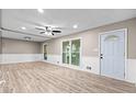 Spacious living room with wood floors, modern ceiling fan, recessed lights, and access to the outside through sliding glass doors at 2617 Peggy Sue Ln, Morrow, GA 30260