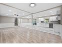 Open-concept living space with wood floors, recessed lighting, and a combination of a living area and a modern kitchen at 2617 Peggy Sue Ln, Morrow, GA 30260
