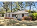 Charming white brick home with manicured lawn and blue Adirondack chairs on the front lawn at 200 Heaton Park Dr, Decatur, GA 30030