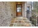 Elegant front entryway with stone steps, brick facade, and a stylish wooden door at 3360 Camellia Ln, Suwanee, GA 30024