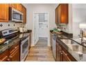 Galley style kitchen boasts stainless steel appliances, dark countertops, and wood cabinets at 325 E Paces Ferry Ne Rd # 410, Atlanta, GA 30305