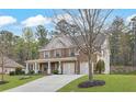 Beautiful two-story home with a manicured lawn, large driveway, and attached two-car garage at 1964 Crosswaters Dr, Dacula, GA 30019