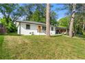 Single-story white home featuring black trim and a bright orange front door with natural landscaping at 2146 Trailwood Rd, Decatur, GA 30032
