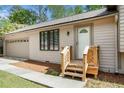 A view of the house's front door entrance with a small wooden porch and a garage in the background at 5286 Westhill Dr, Norcross, GA 30071
