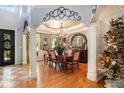 Formal dining room featuring view to foyer, columns, hardwood floor, & Christmas tree at 3907 Fellowship Dr, Buford, GA 30519