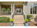 Inviting front entrance with brick steps leading to a covered porch and stylish double doors at 9075 Preston Ln, Suwanee, GA 30024