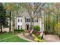 Beautiful two-story home with manicured lawn, mature trees, and an American flag displayed at 1209 Fern Hollow Dr, Woodstock, GA 30189