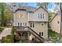 Two-story home featuring a rear deck with backyard access and lush backyard at 1209 Fern Hollow Dr, Woodstock, GA 30189