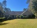 Charming single-story home featuring a well-manicured lawn and mature trees at 135 Lucky Leaf Pl, Fayetteville, GA 30214