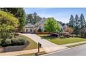 Charming two-story white home with well-maintained landscaping and a long driveway at 1010 Lake Shore Overlook, Alpharetta, GA 30005