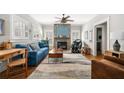 Inviting living room features a stone fireplace, large windows, and hardwood floors, bathed in natural light at 2964 Anderson Se Cir, Smyrna, GA 30080