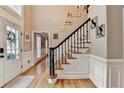Inviting foyer with hardwood floors, staircase with wrought iron spindles and neutral walls at 3045 Hartridge Dr, Johns Creek, GA 30022
